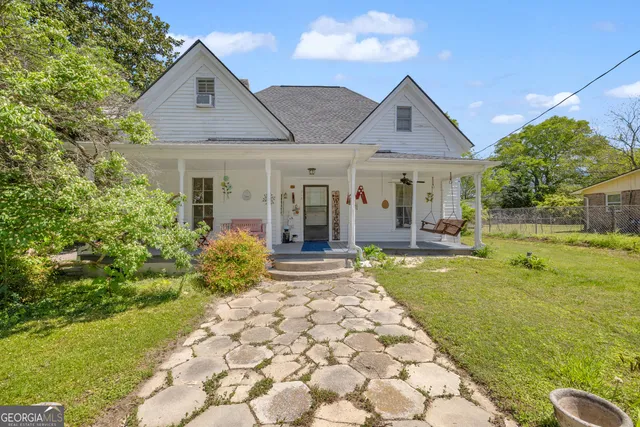 a kitchen with stainless steel appliances kitchen island granite countertop a stove a sink and white cabinets