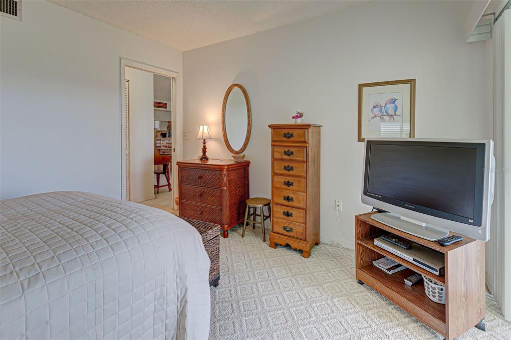 418 Cerromar Court, Unit 261 Venice, FL 34293 - Photo 32 of 76 a bedroom with a bed and a flat screen tv
