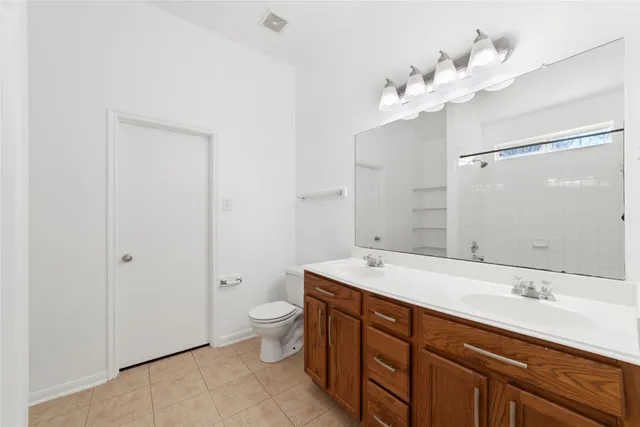 a bathroom with a double vanity sink mirror and toilet