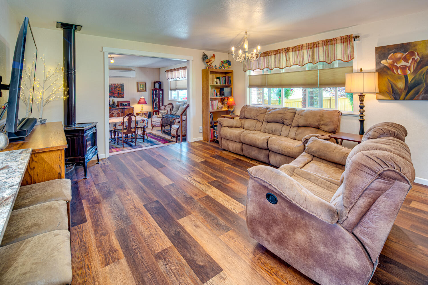 2218 Southwest 79th Street Redmond, OR 97756 - Photo 6 of 54 a living room with furniture a lamp wooden floor and a large window