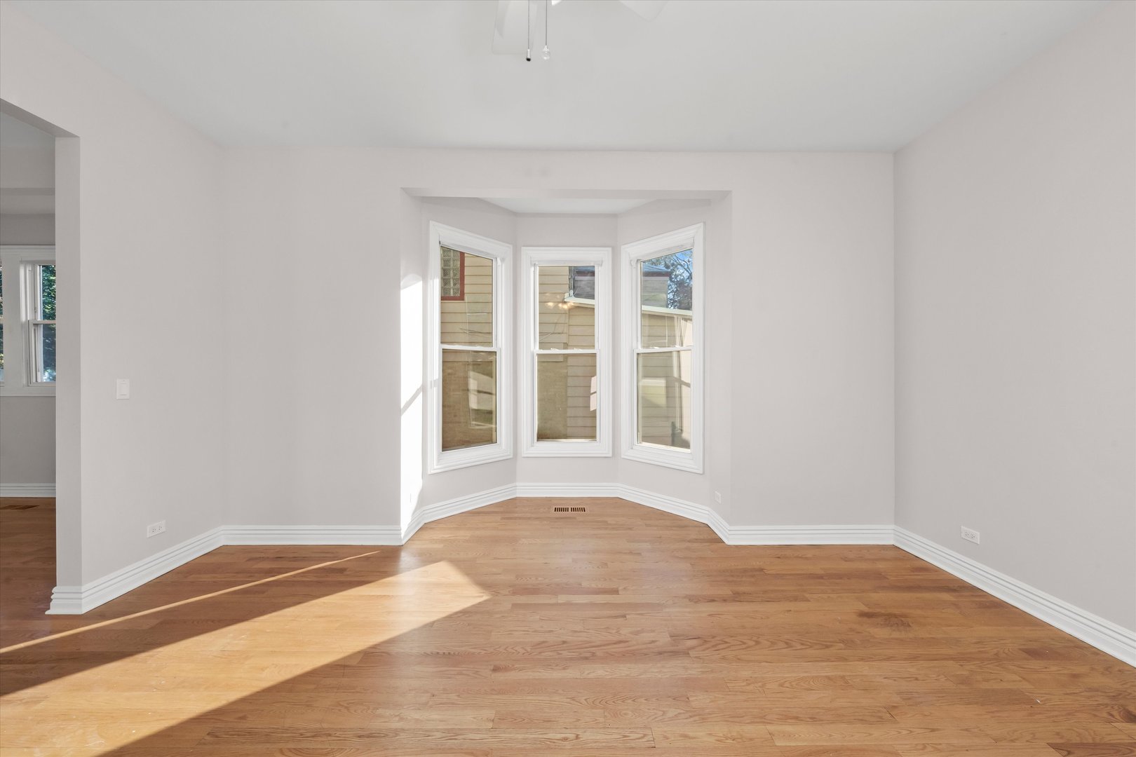 197 Herrick Road Riverside, IL 60546 - Photo 5 of 45 a view of an empty room with wooden floor and a window