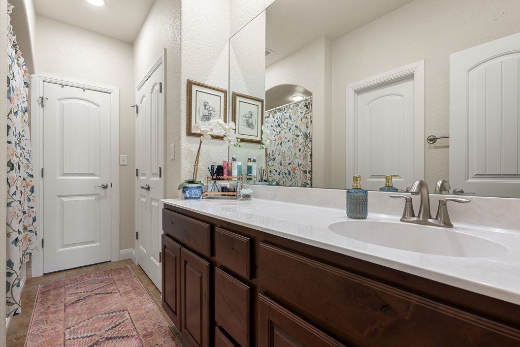 6708 Menchaca Road, Unit 2 Austin, TX 78745 - Photo 23 of 30 Bathroom vanity with a single basin sink, brushed nickel faucet, and a large wall-mounted mirror