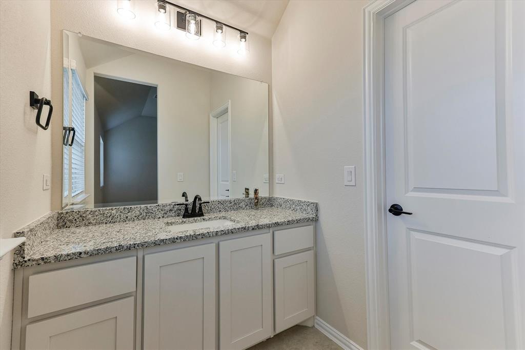 10 Covey Lane Sanger, TX 76266 - Photo 23 of 29 a bathroom with a granite countertop sink and a mirror