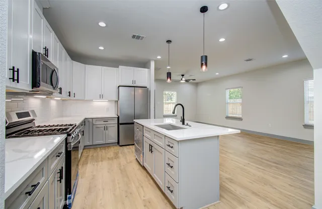a kitchen with stainless steel appliances granite countertop a sink stove and refrigerator