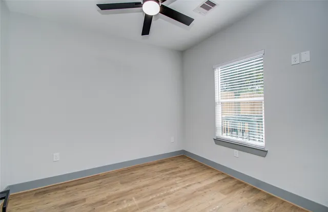 wooden floor in an empty room with a window
