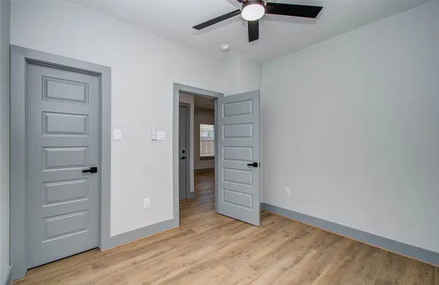 an empty room with closet and a ceiling fan