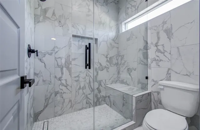 a bathroom with a toilet and a shower