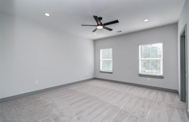 an empty room with a window and a fan
