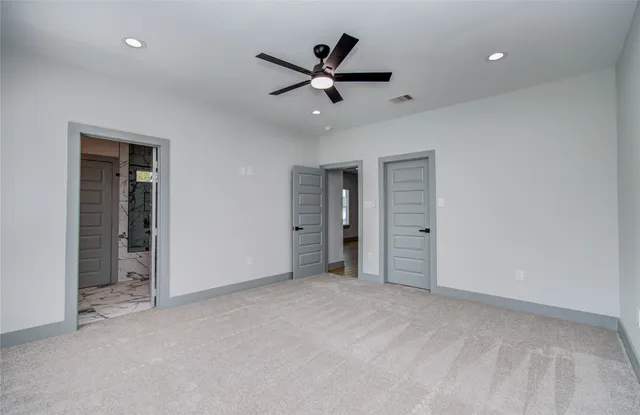 an empty room with closet and ceiling fan
