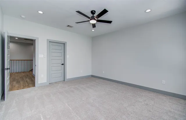 an empty room with closet and ceiling fan