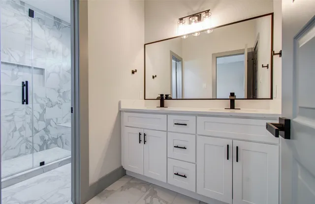 a bathroom with a shower sink and mirror