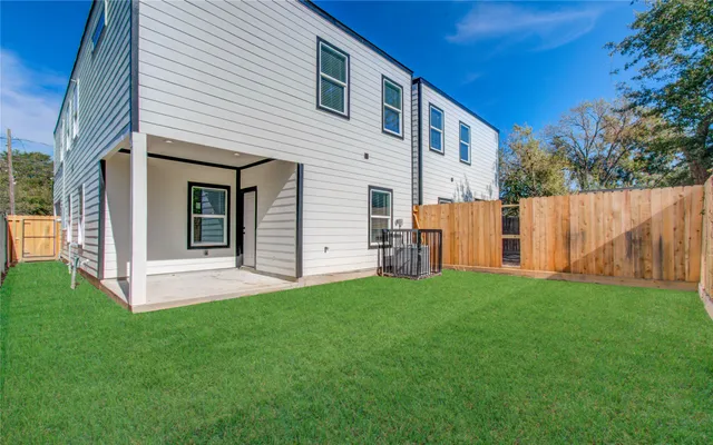 a view of a backyard with a house and wooden fence