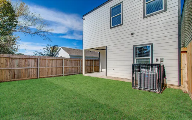 a view of backyard with wooden fence