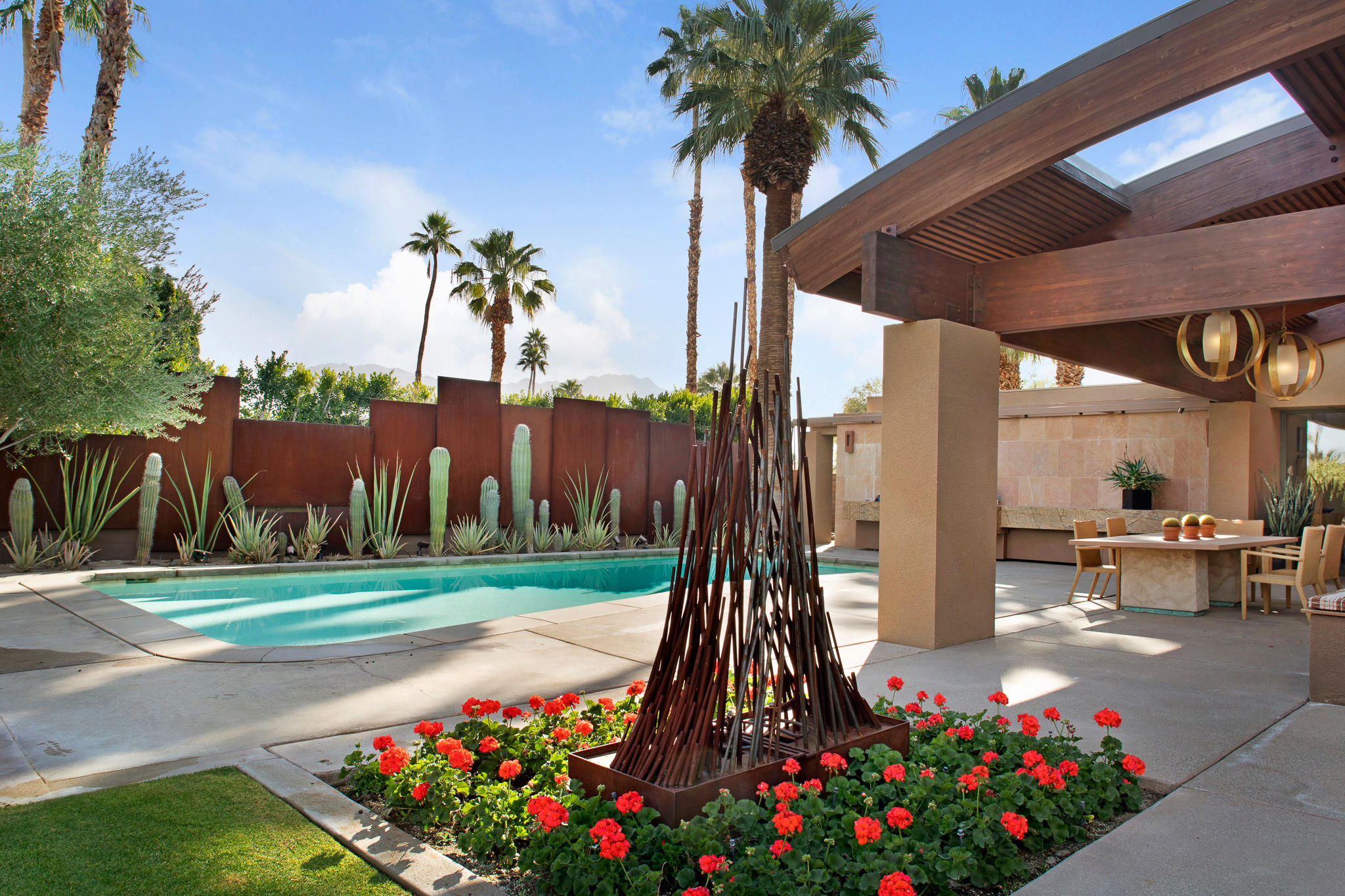 73580 Broken Arrow Trail Palm Desert, CA 92260 - Photo 8 of 40 a front view of a house with a garden and trees