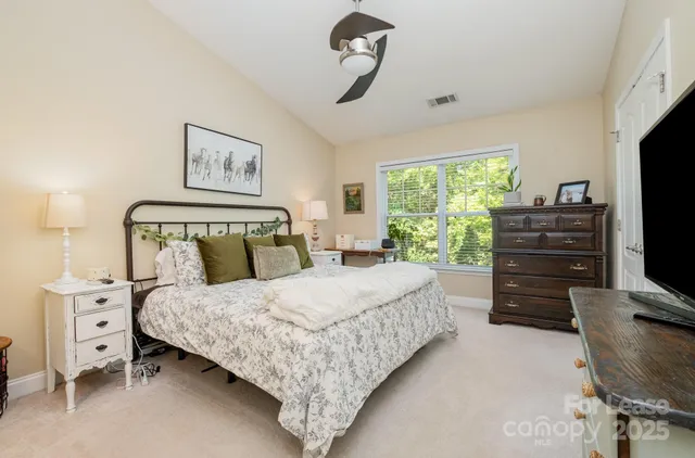 a bedroom with a bed and a flat tv screen on dresser