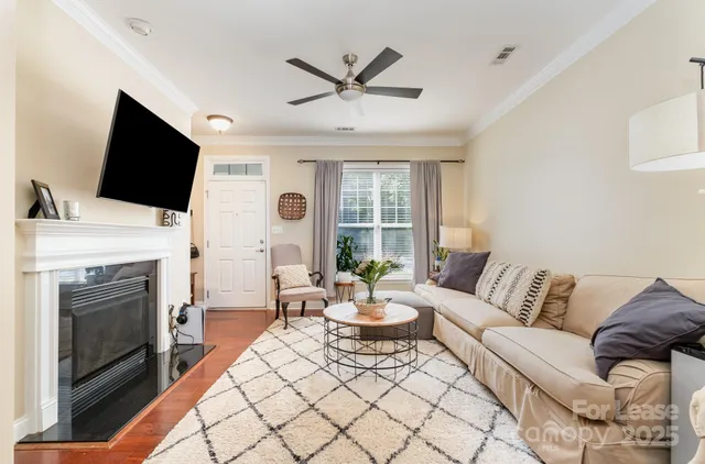 a living room with furniture a fireplace and a flat screen tv