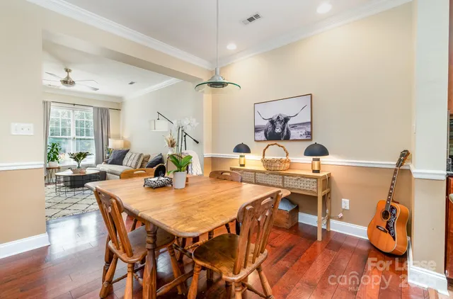 a view of a dining room and livingroom with furniture wooden floor a chandelier
