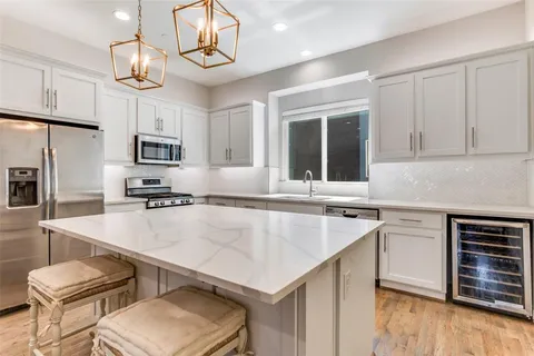 a kitchen with cabinets a center island and appliances