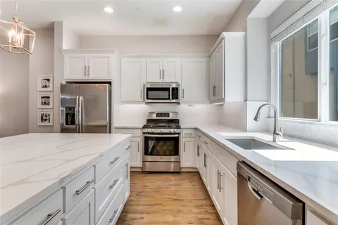 a kitchen with white cabinets and stainless steel appliances