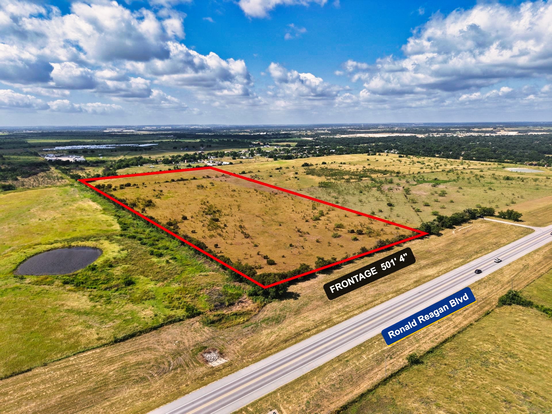 Tbd Ronald Reagan Boulevard Georgetown, TX 78633 - Photo 3 of 12 A spacious, undeveloped parcel with significant frontage on a major boulevard, offering diverse terrain and a tranquil pond.