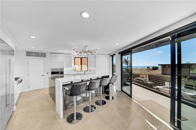 a kitchen with stainless steel appliances kitchen island granite countertop a table and chairs in it
