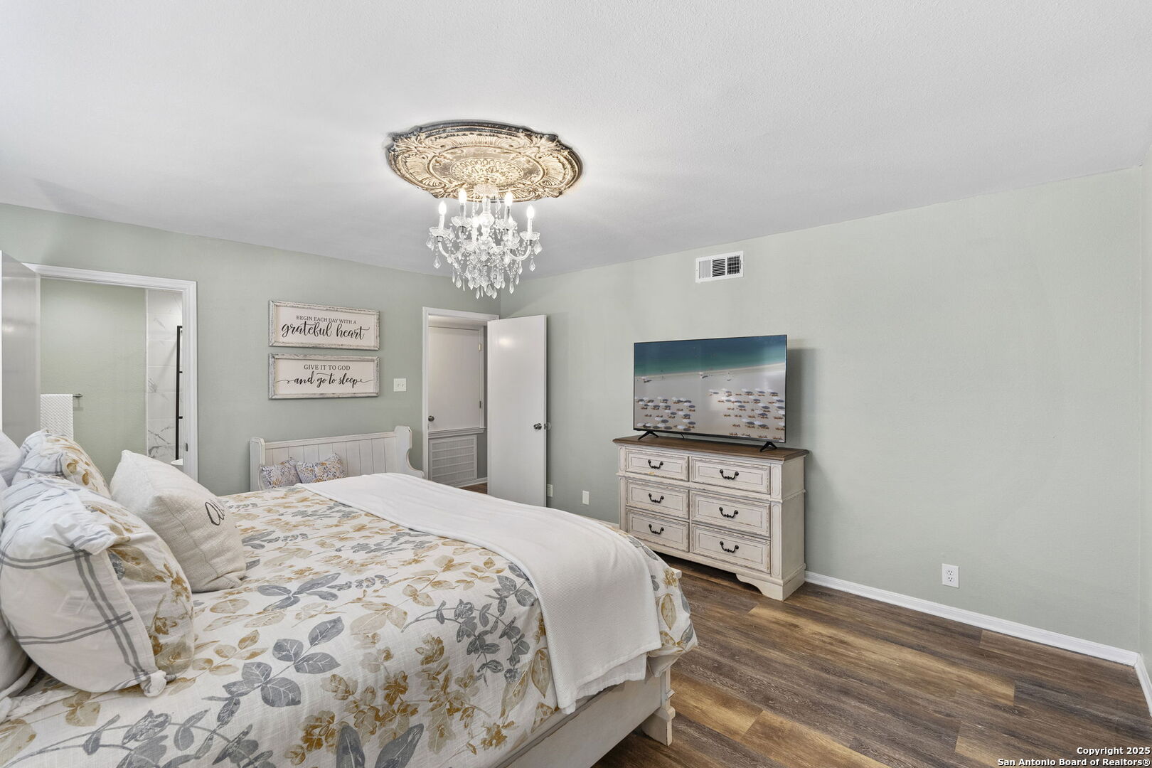 668 Indian Mound Road Tarpley, TX 78883 - Photo 30 of 50 a bedroom with a bed and a chandelier