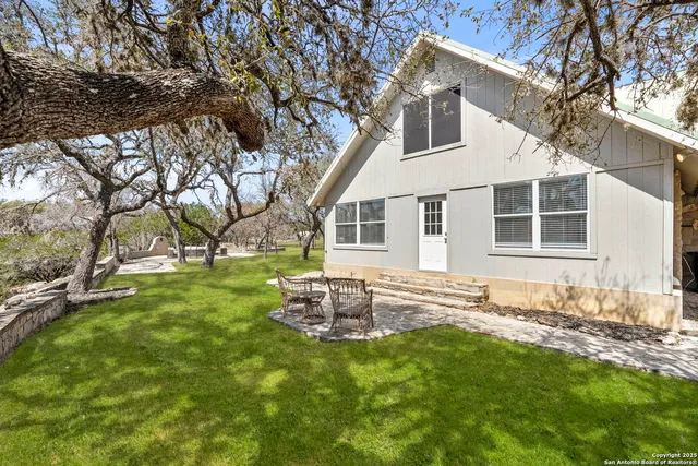 a backyard of a house with table and chairs