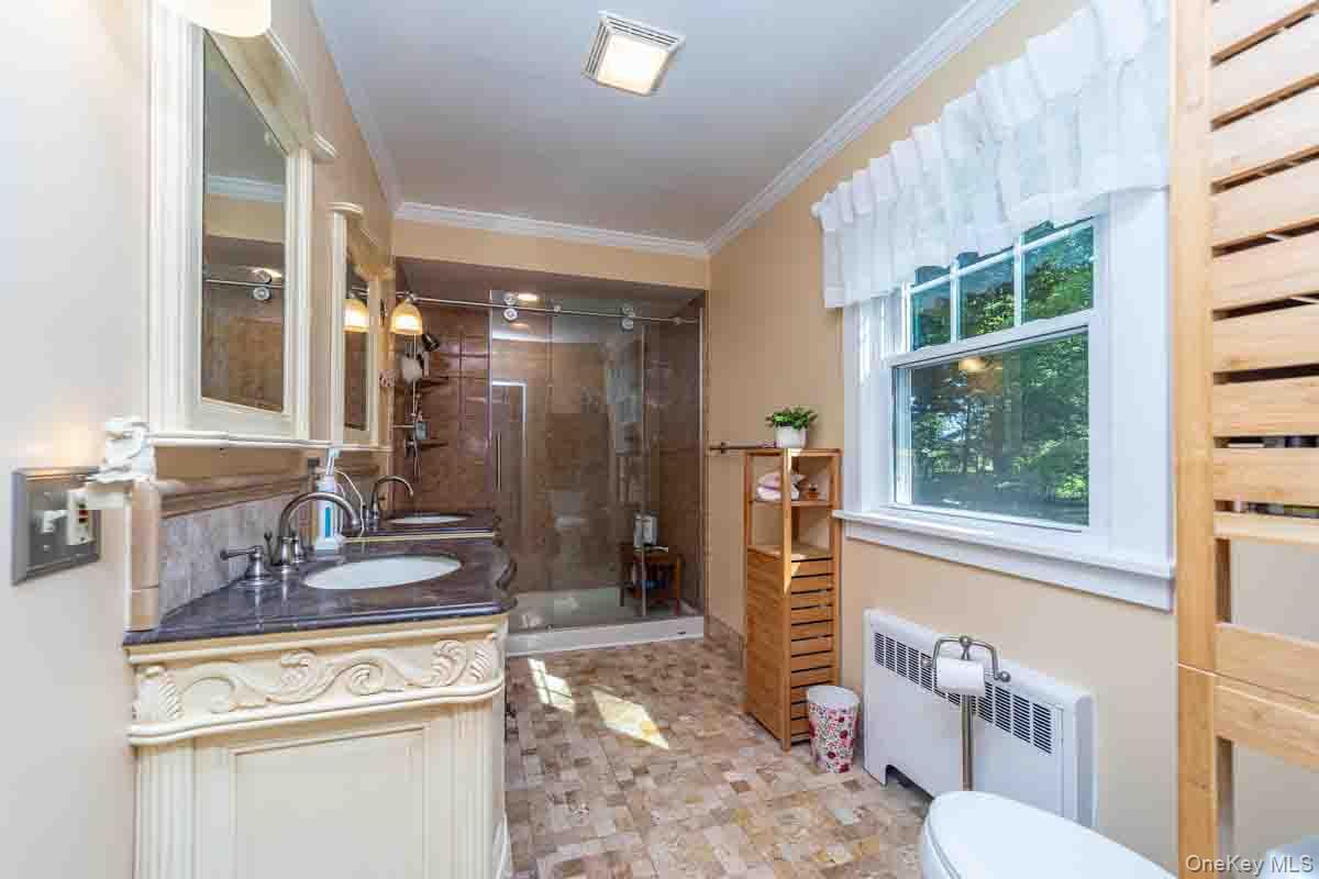 145 Drake Road Pleasant Valley, NY 12569 - Photo 26 of 47 Dual vanity with dark stone countertop, built-in medicine cabinets, tile flooring, and glass-enclosed shower