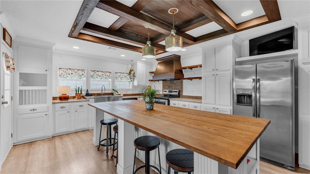 3182 Indian Ridge Place Lakeland, FL 33810 - Photo 23 of 45 a room with stainless steel appliances kitchen island a table chairs in it and wooden floors