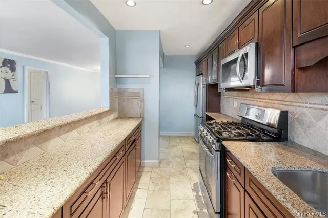 a view of a kitchen with stainless steel appliances granite countertop a refrigerator and a sink