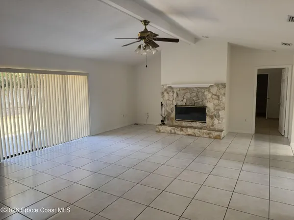 an empty room with fireplace and windows