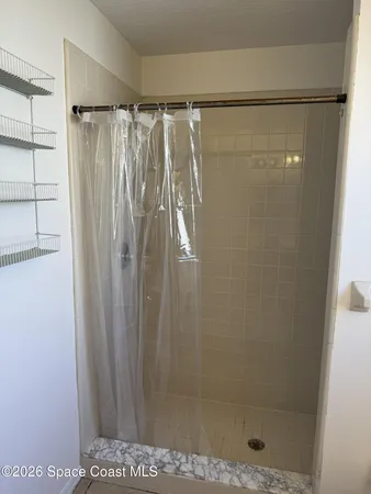 a bathroom with a shower and a glass door