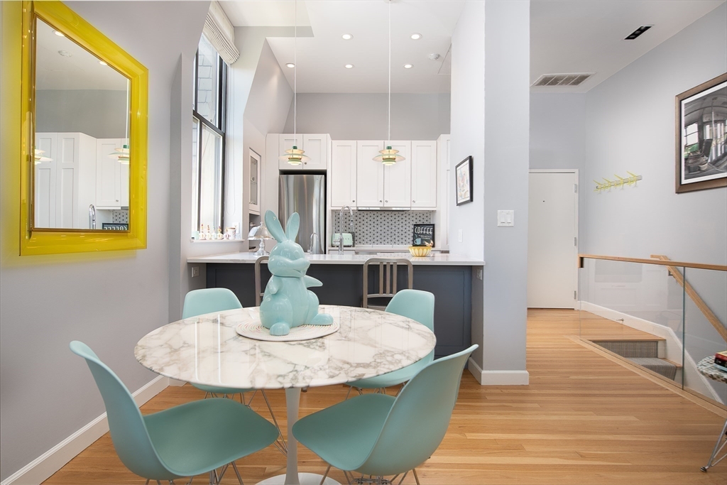 130 Appleton Street, Unit 4D Boston, MA 02116 - Photo 7 of 34 a kitchen with stainless steel appliances granite countertop a table chairs and a refrigerator