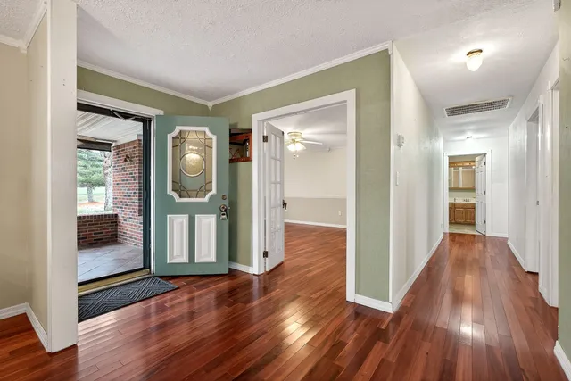a view of a backyard with swimming pool and large trees