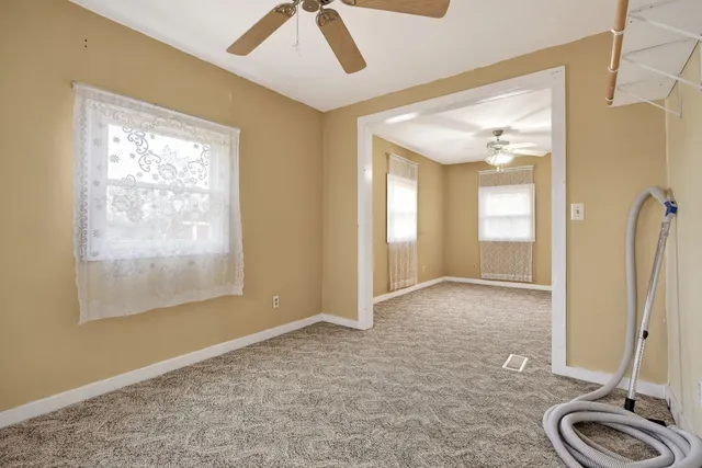 wooden floor in an empty room with a mirror and a window