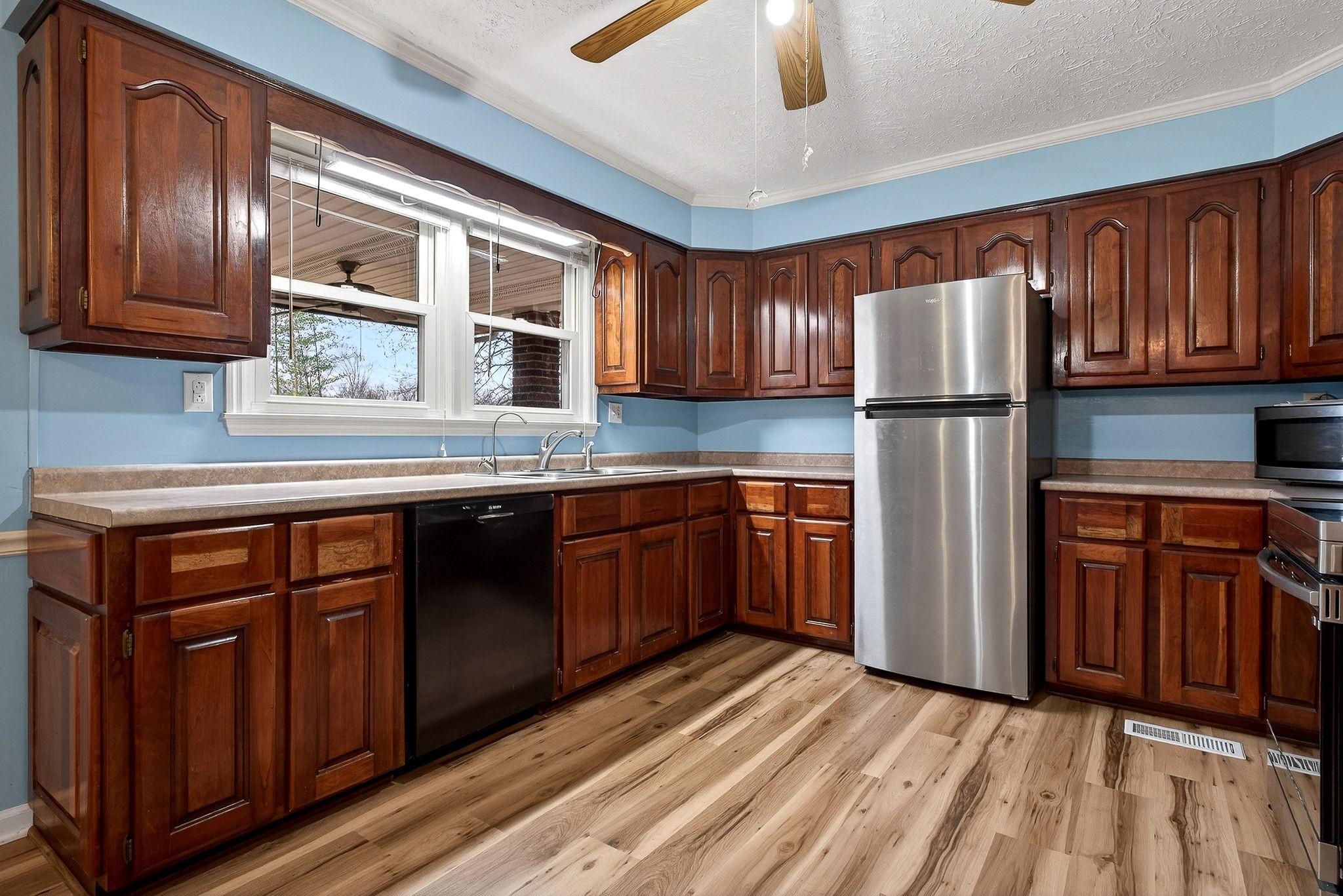 850 Wesley Chapel Road Sparta, TN 38583 - Photo 59 of 68 a kitchen with stainless steel appliances granite countertop a refrigerator a sink dishwasher and wooden cabinets with wooden floor