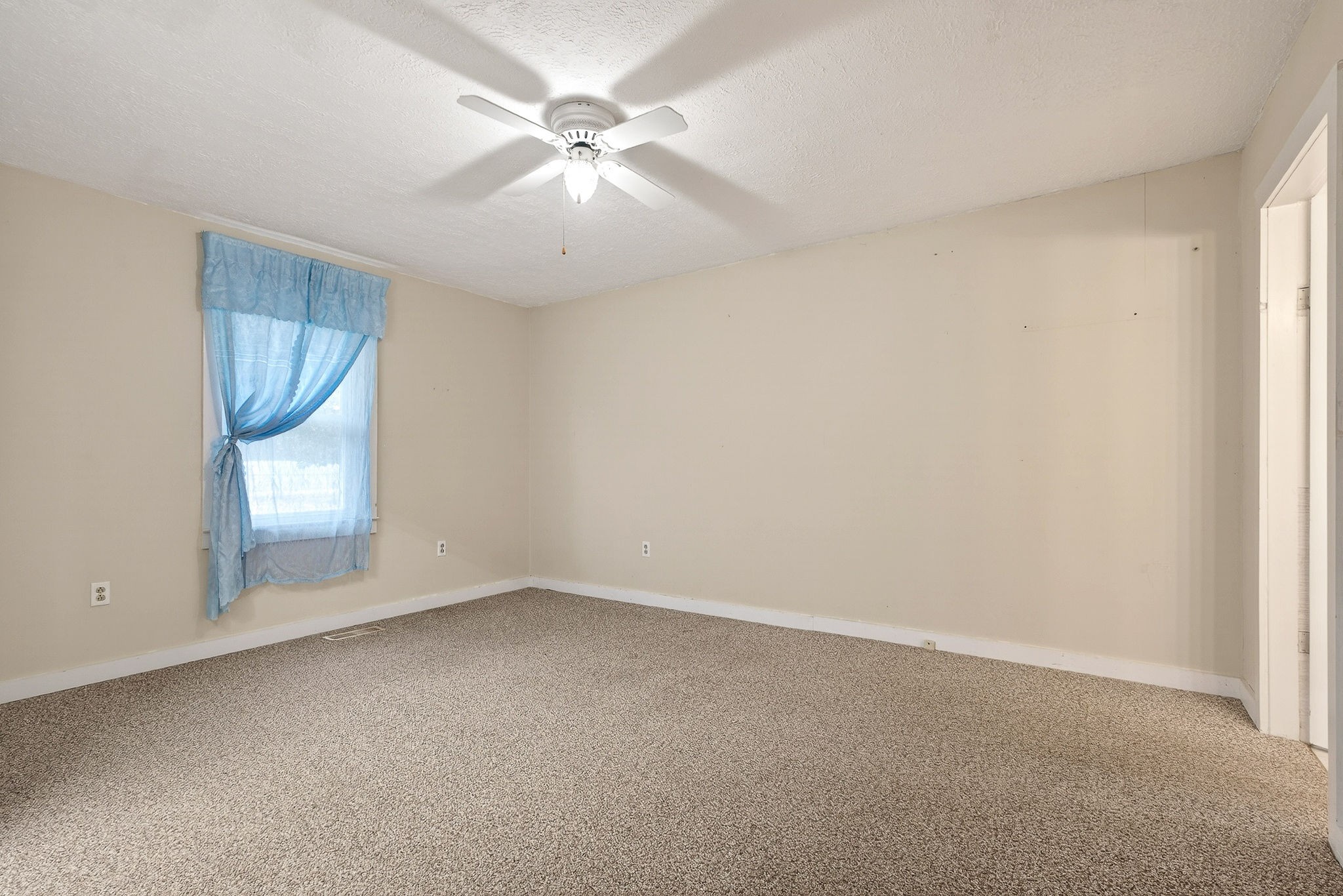 850 Wesley Chapel Road Sparta, TN 38583 - Photo 68 of 68 an empty room with a chandelier fan and windows