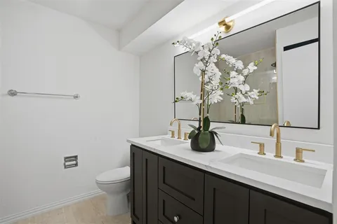a bathroom with a granite countertop sink a toilet and a mirror