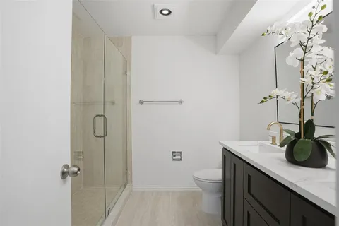 a bathroom with a sink a toilet and shower