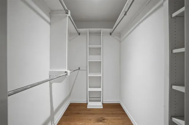 a view of walk in closet with empty racks