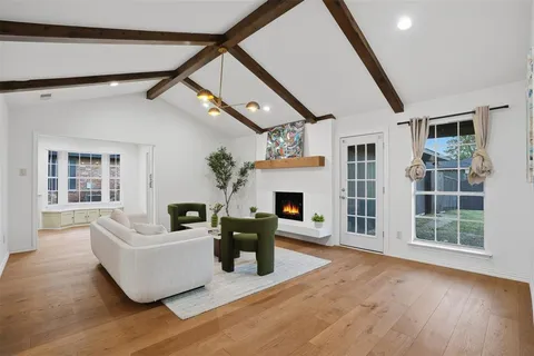 a living room with furniture a fireplace and a floor to ceiling window