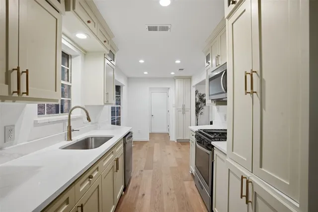 a kitchen with stainless steel appliances granite countertop a sink stove and refrigerator