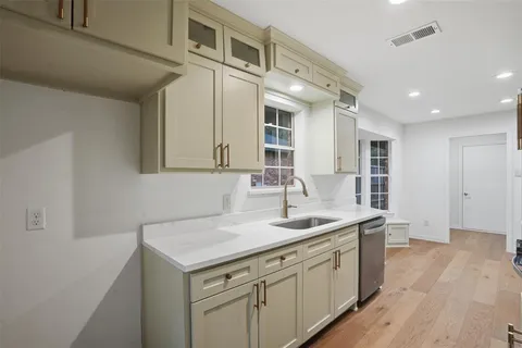 a kitchen with a sink cabinets and wooden floor