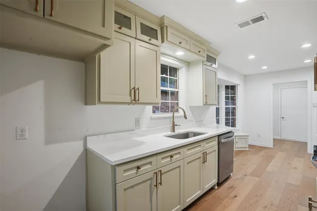 a kitchen with a sink cabinets and wooden floor