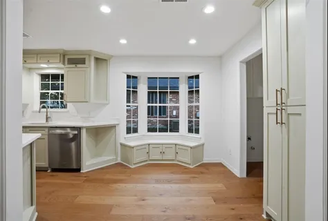 a view of an empty room with a kitchen and a window