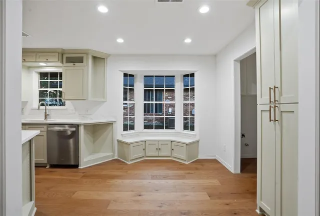 a view of an empty room with a kitchen and a window
