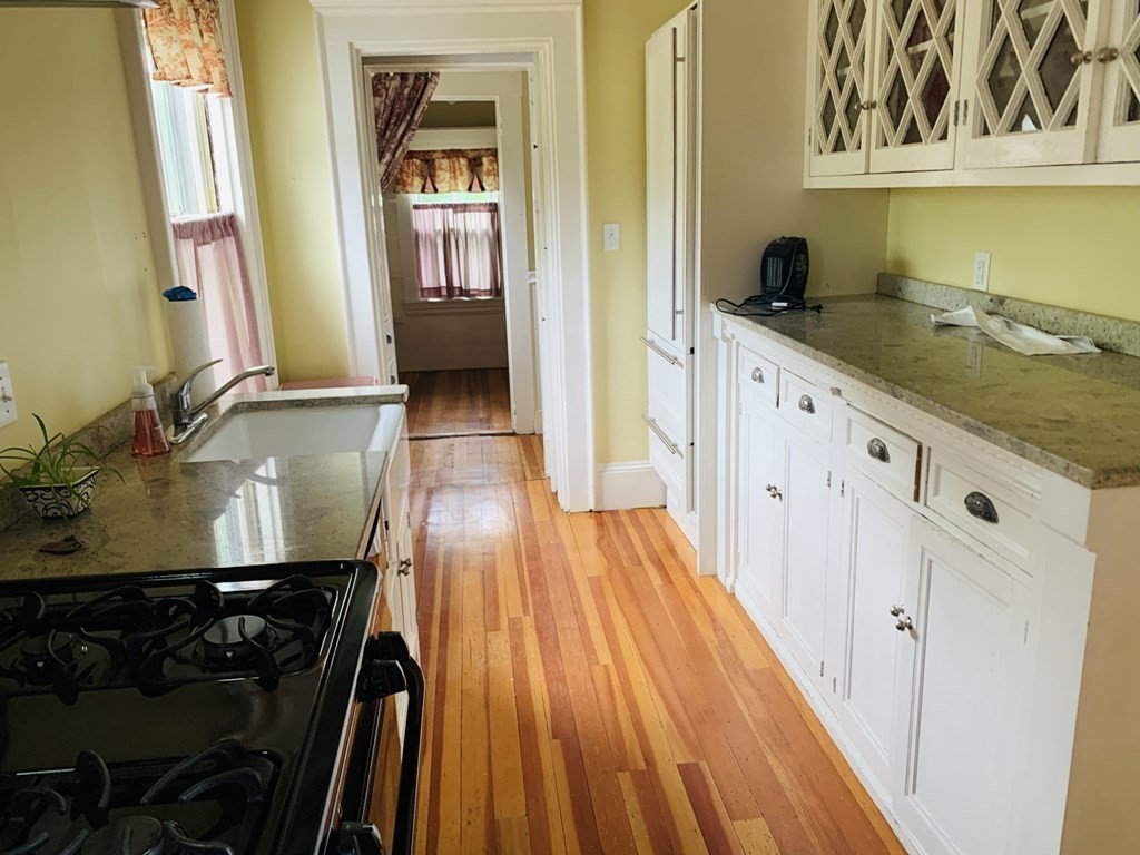 a kitchen with a sink and wooden floor