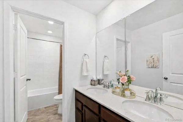 a bathroom with a granite countertop sink a toilet and shower