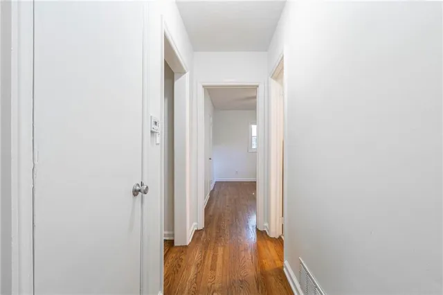 a view of a hallway with wooden floor and closet