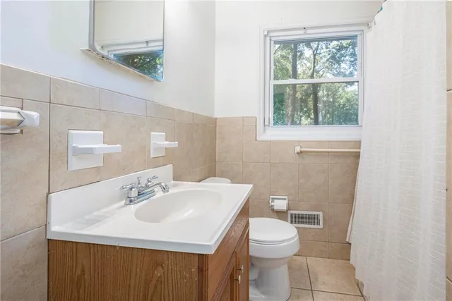 a bathroom with a sink a toilet and a window